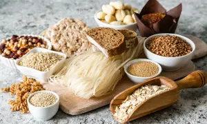 Różnorodne produkty bezglutenowe: ryż, gryka, makaron ryżowy, płatki owsiane, komosa ryżowa, ciecierzyca, fasola, chleb. Czy jęczmień ma gluten? Nie ma go na tym zdjęciu.