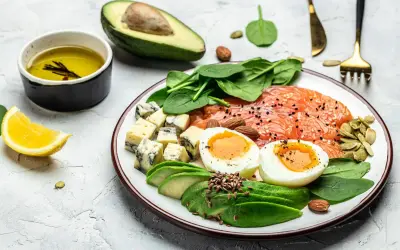 Pyszne danie zgodne z dieta keto zasady: łosoś, jajka, awokado, ser pleśniowy, szpinak i migdały.