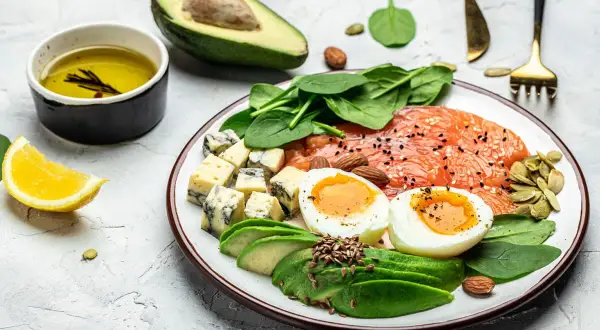 Pyszne danie zgodne z dieta keto zasady: łosoś, jajka, awokado, ser pleśniowy, szpinak i migdały.