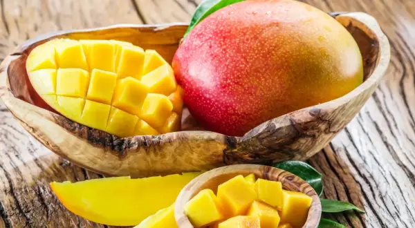 Soczyste mango, pokrojone w kostkę i w całości, w drewnianych miseczkach. To owoc, który jest dobry na wszystko: od orzeźwienia po witaminy.