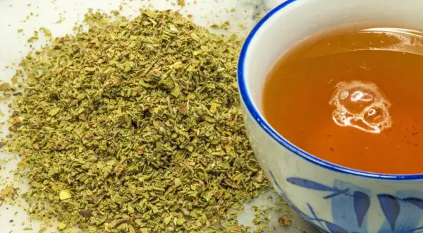 Kopiec suszonego czystka obok filiżanki aromatycznej herbaty. Czystek jest znany ze swoich właściwości.