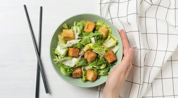 Sałatka z chrupiącym tofu – idealna, gdy szukasz, czym zastąpić mięso. Podana z pałeczkami.