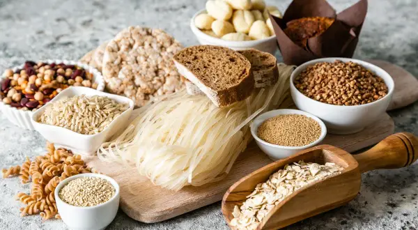 Różnorodne produkty bezglutenowe: ryż, gryka, makaron ryżowy, płatki owsiane, komosa ryżowa, ciecierzyca, fasola, chleb. Czy jęczmień ma gluten? Nie ma go na tym zdjęciu.