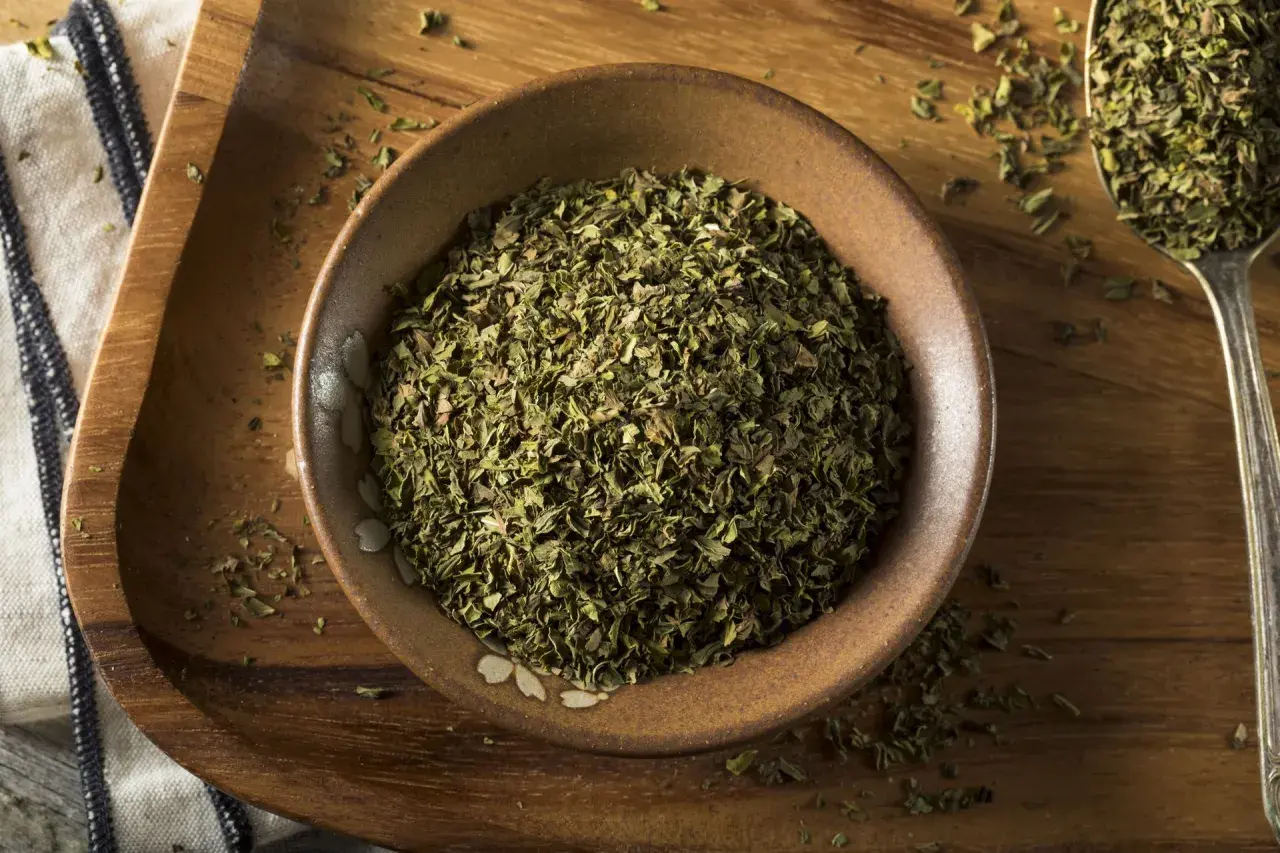 Suszone oregano w miseczce i na łyżce. Poznaj oregano właściwości i dodaj aromatu potrawom.