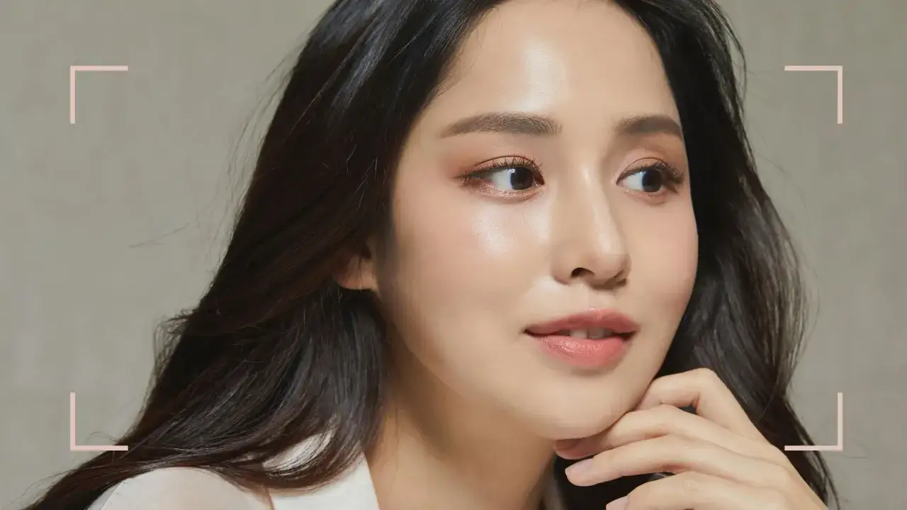 Delikatna koreanki uroda, z subtelnym makijażem podkreślającym naturalne piękno. Skóra lśni zdrowiem, a spojrzenie jest pełne wdzięku.