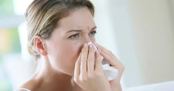 Kobieta z chusteczką przy nosie, szukająca naturalnych sposobów na alergię.