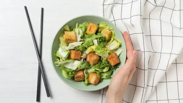 Sałatka z chrupiącym tofu – idealna, gdy szukasz, czym zastąpić mięso. Podana z pałeczkami.